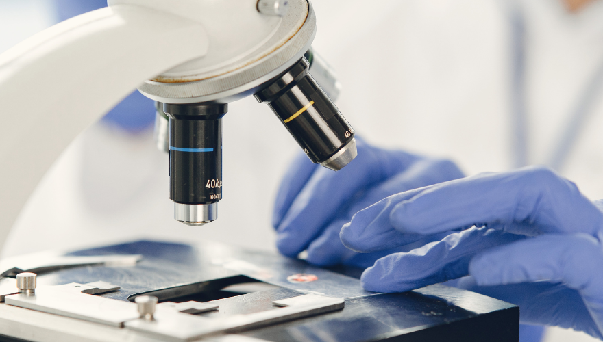 Close up of hands working on a microscope