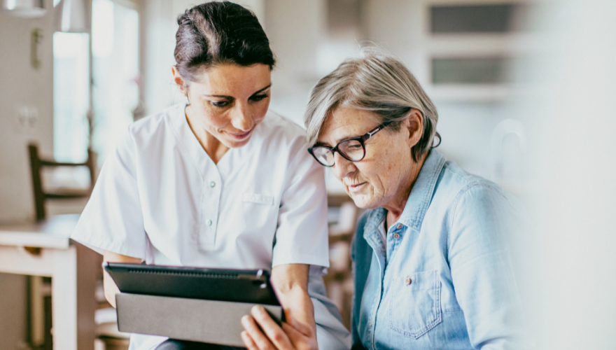 Woman and nurse looking at a tablet