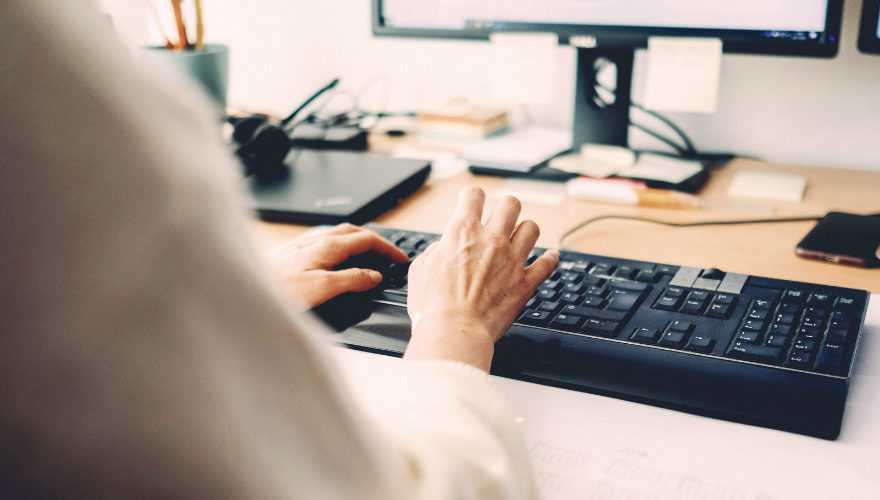 A photo of someone's hands typing on a keyboard