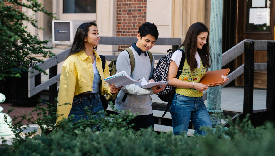 Three Asian college students walking to class.