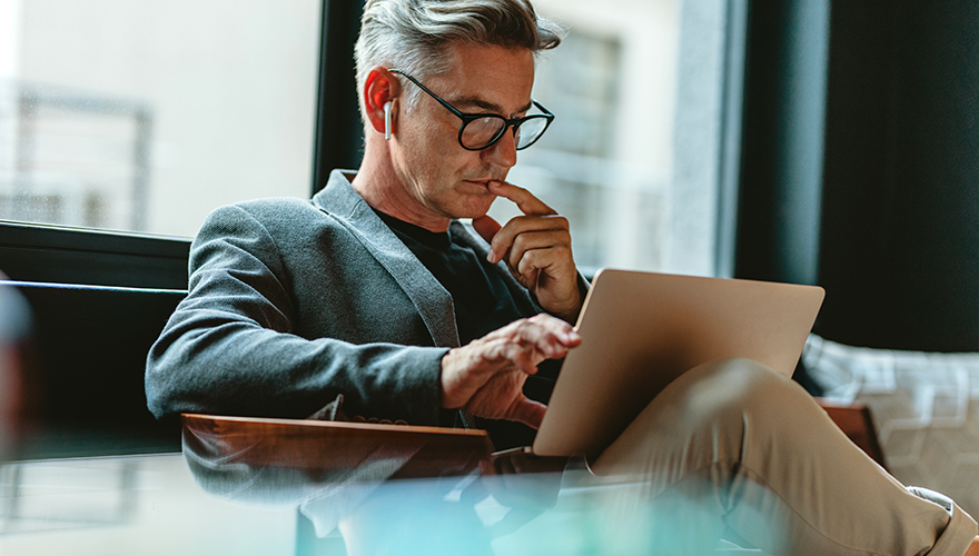 Older man contemplating something on his tablet