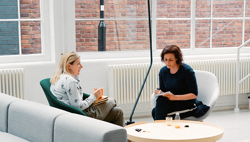 Photo of two women in an office discussing something