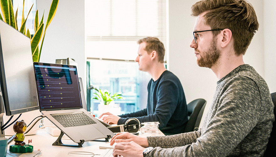 Photo of two men working at their desks