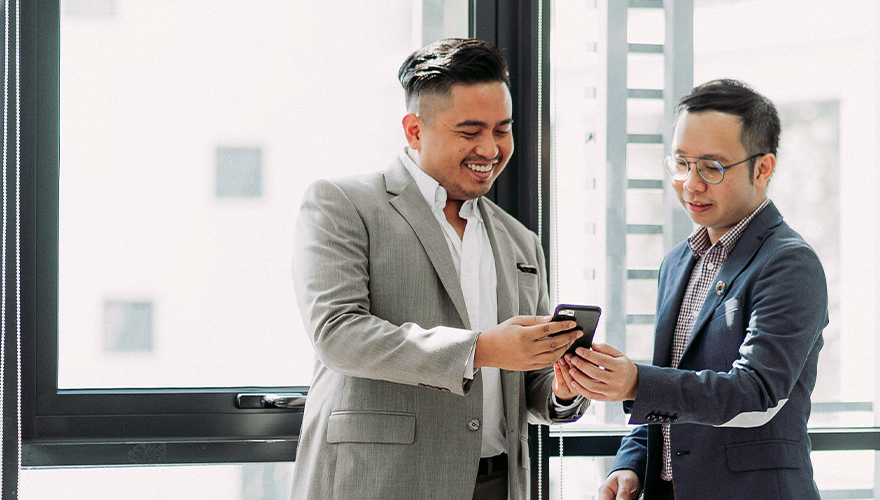 Photo of two talent acquisition leaders discussing and looking at a cellphone