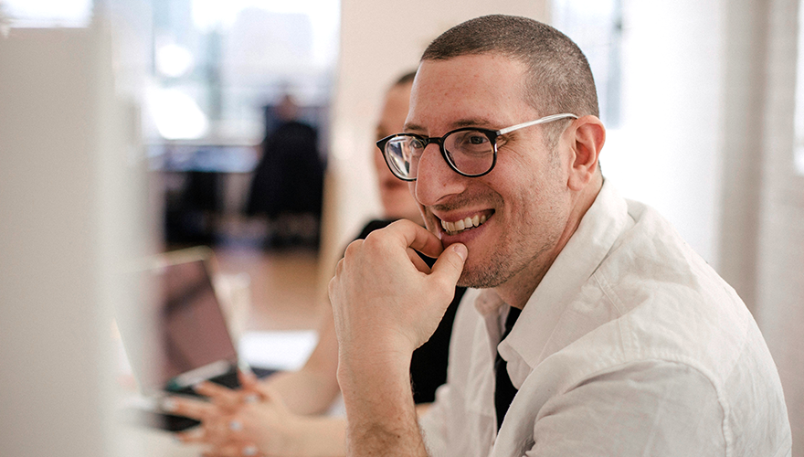 Photo of a man in a meeting smiling warmly