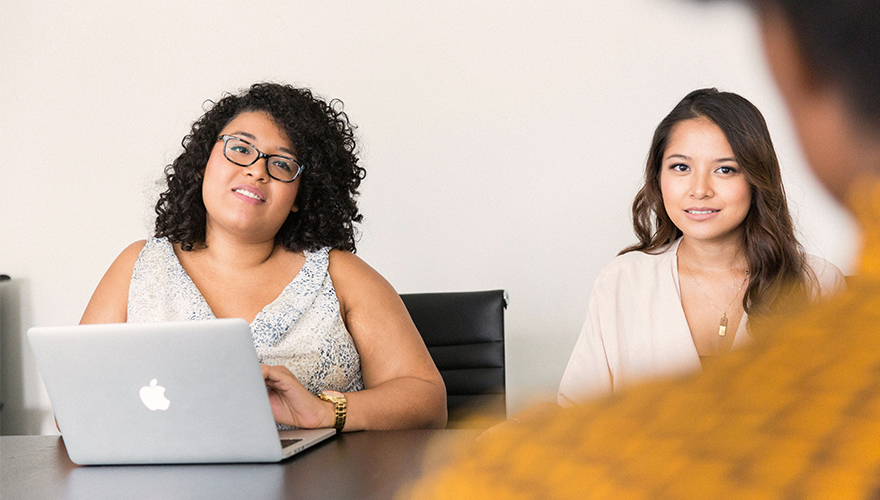 Two women sitting at a conference table