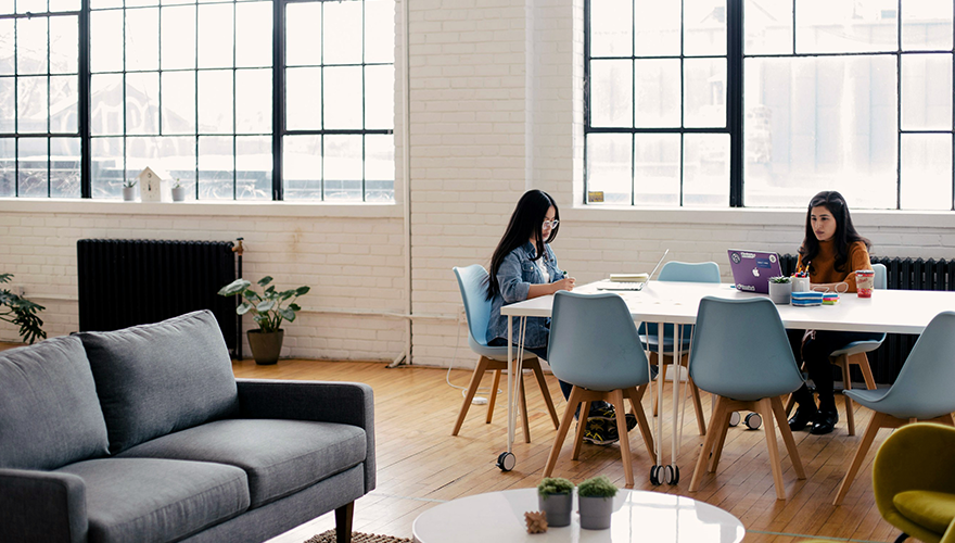 Photo of two coworkers working at a conference table