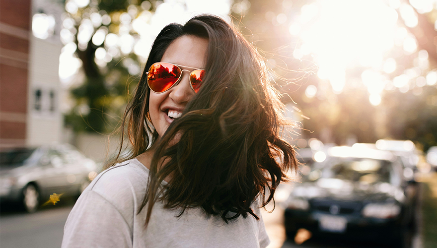 A photo of a smiling woman wearing sunglasses